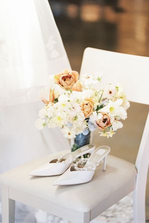 White gift boxes topped with delicate peach and white floral arrangements on display.