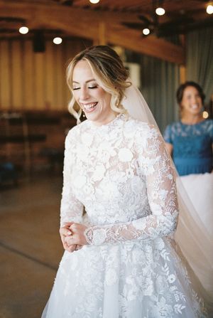 A wedding dress featuring delicate lace details and long sleeves in an indoor venue.