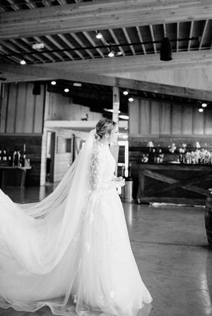 Ethereal white wedding dress billowing on empty dance floor with dramatic lighting.