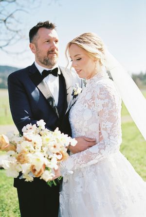Romantic outdoor wedding moment captured against a sunny spring backdrop.