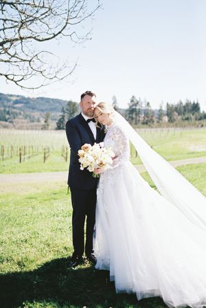A romantic outdoor wedding portrait in a scenic countryside setting.