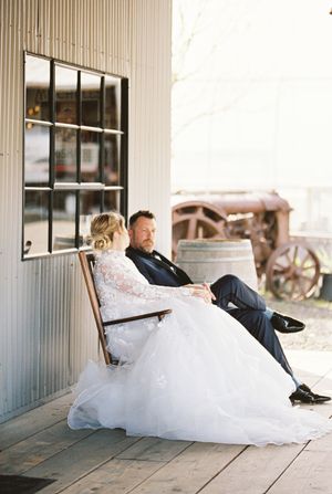 Wedding couple relaxing on a rustic wooden porch during their special day.