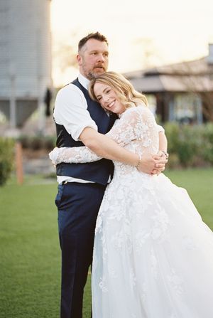 Newlyweds sharing an intimate dance moment on a grassy lawn.