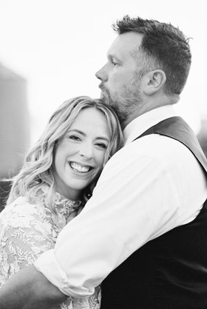 An intimate black and white portrait of newlyweds sharing a tender moment.