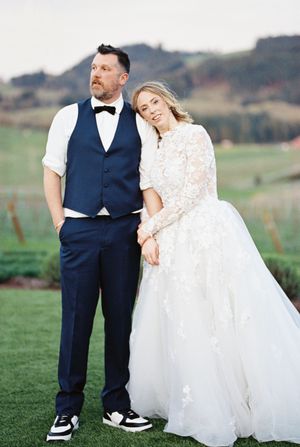 Romantic wedding portraits on a scenic hilltop with mountains in the background.