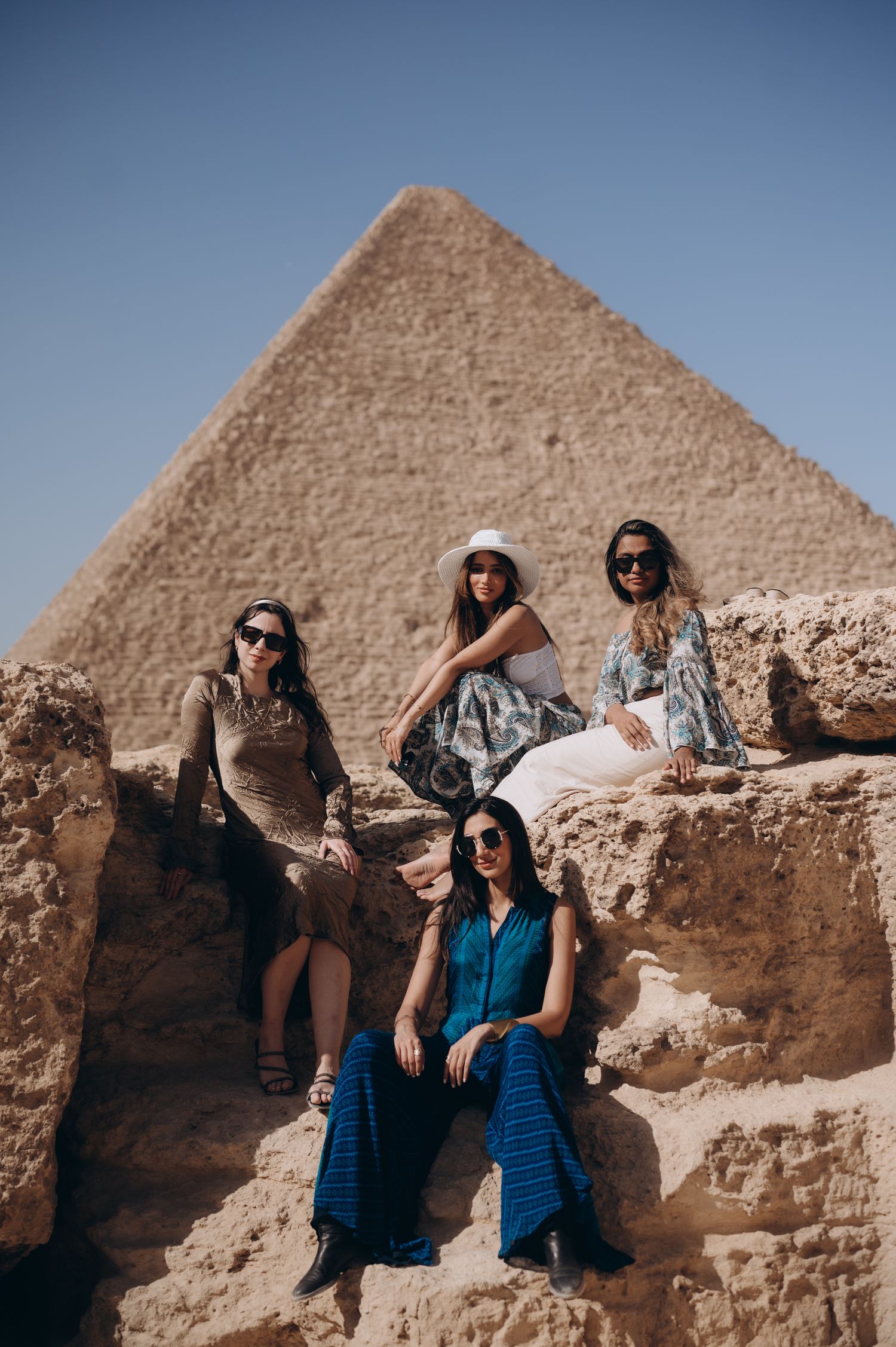 Group enjoying scenic view of the Great Pyramid from rocky outcrop in Egypt.