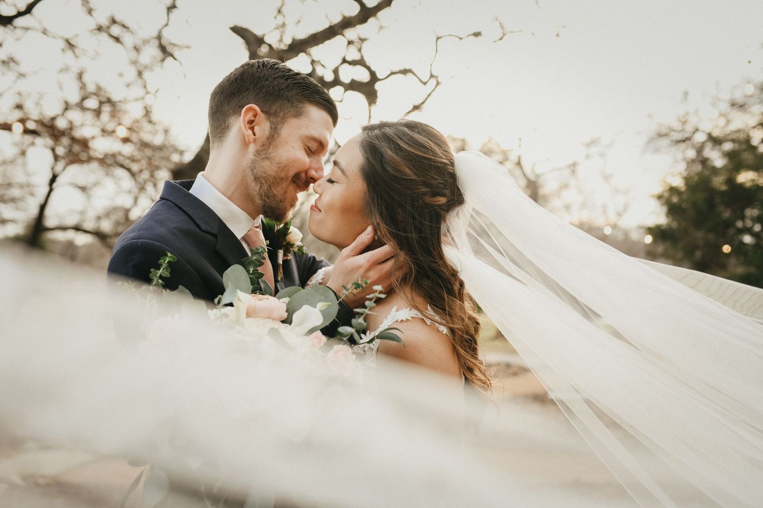 romantic portrait of bride and groom kissing at oak and ivy wedding venue