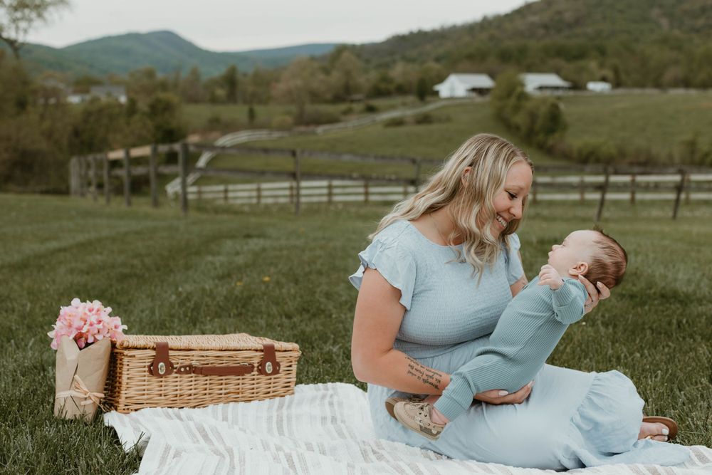 Spring family portraits in a rustic mountain setting with white picnic blanket.