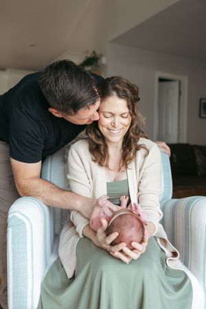 A series of tender moments captured between a couple and their newborn baby on a light-colored couch.