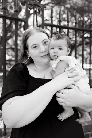 A black and white photo sequence shows a parent in dark clothing holding and interacting with a small baby.