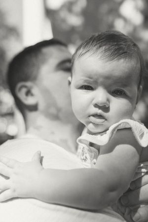 Close-up black and white portraits of a baby's expressive face showing various emotions.