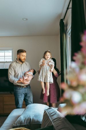 A family shares a tender moment together in a living room with soft natural light streaming through the window.