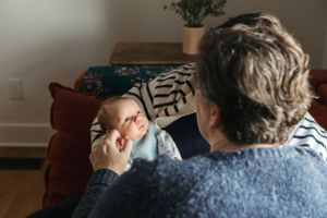Two people share a quiet moment together while relaxing on a brown couch in a cozy living room.