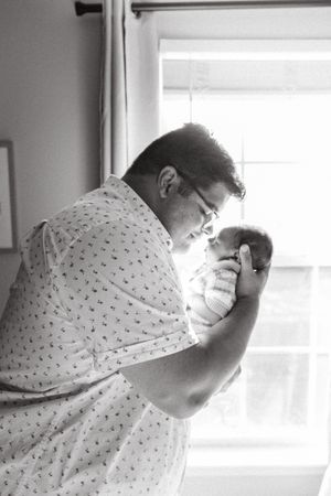 A series of black and white images showing someone in a patterned hospital gown leaning forward in distress.