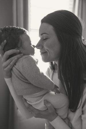 A series of black and white photos showing tender moments between parent and baby in natural light.