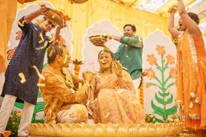 Haldi celebration scene with guests dressed in vibrant outfits, enjoying the festivities under decorative lights.