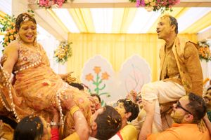 Haldi celebration scene with guests dressed in vibrant outfits, enjoying the festivities under decorative lights.