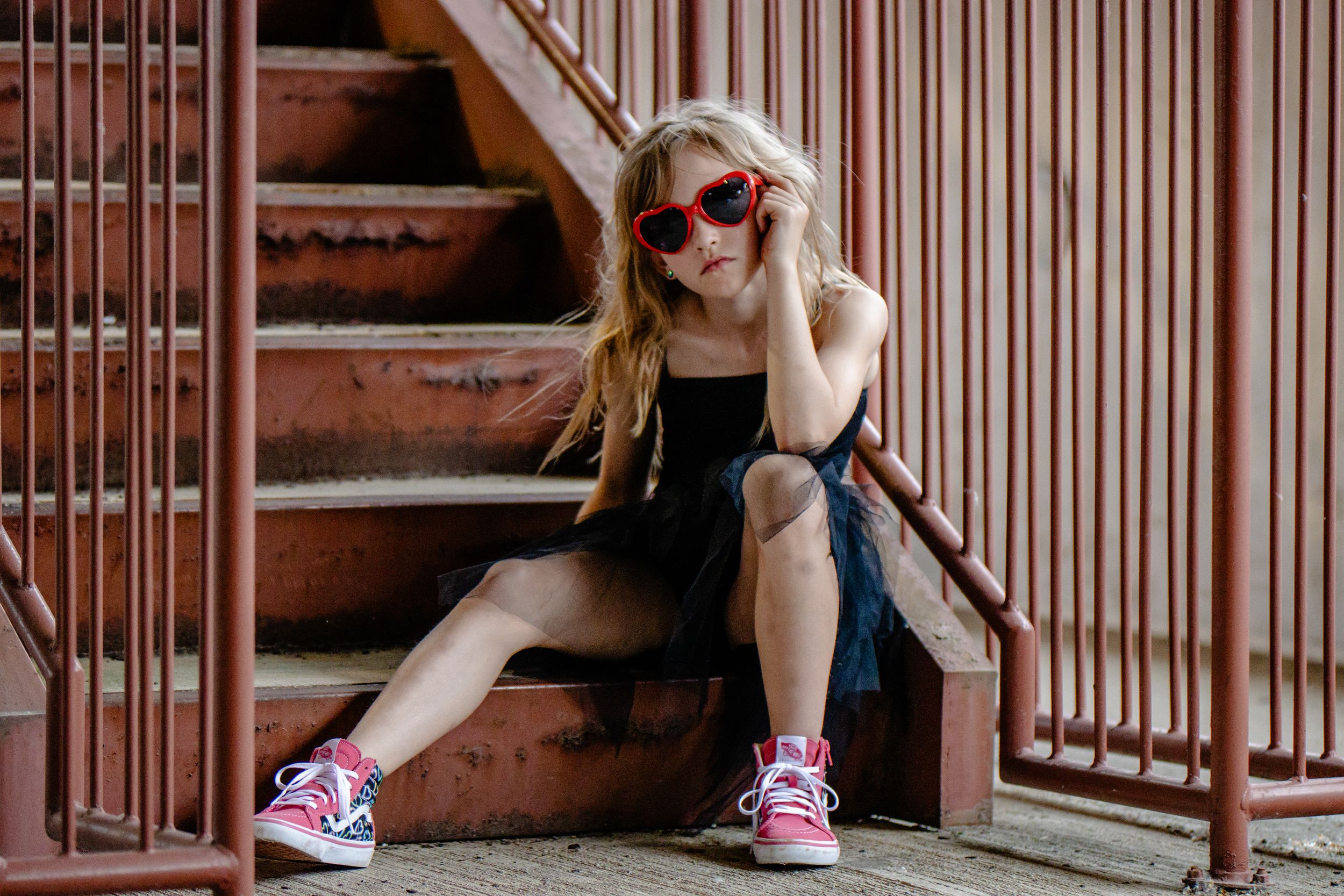 Series of casual poses on rustic brown metal stairs with sneakers visible.