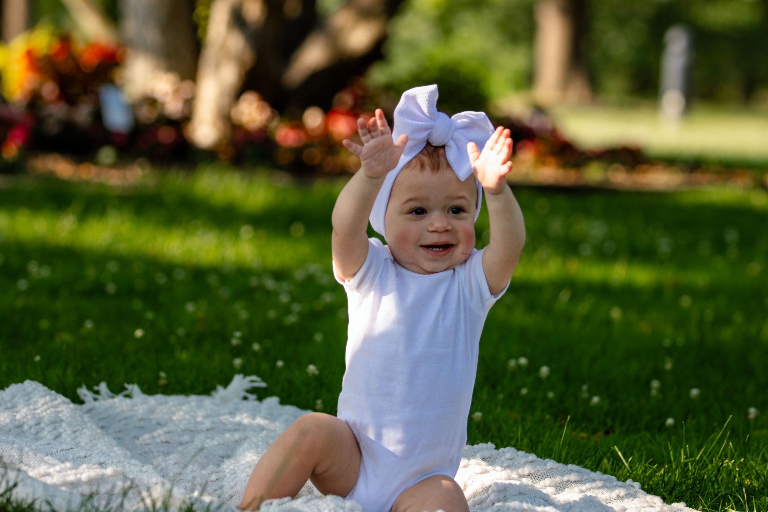 Candid moments captured on lush green grass during a sunny outdoor photoshoot.