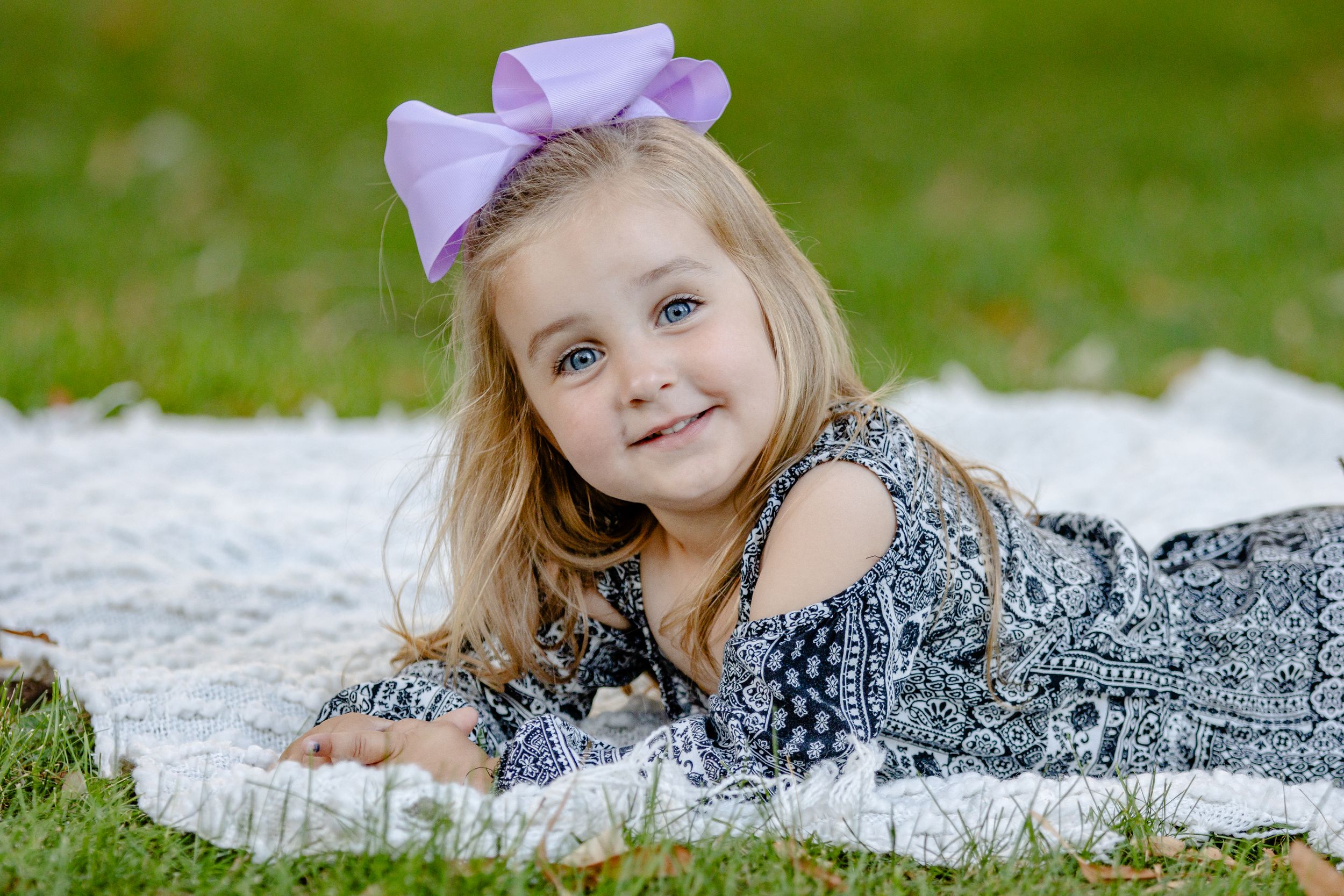 A series of outdoor portrait shots on grass with purple accessories.