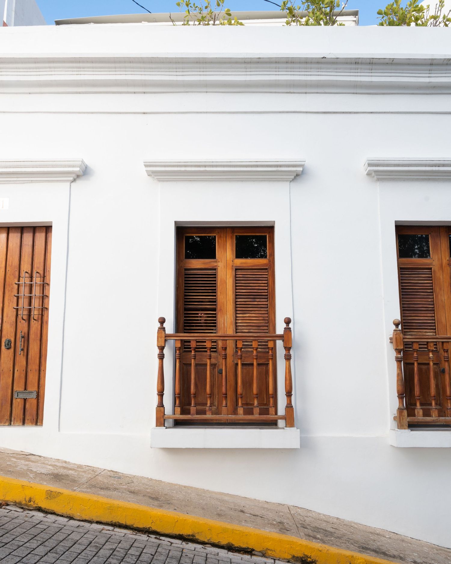 Colonial style white building facade with wooden doors and balconies in Old San Juan.