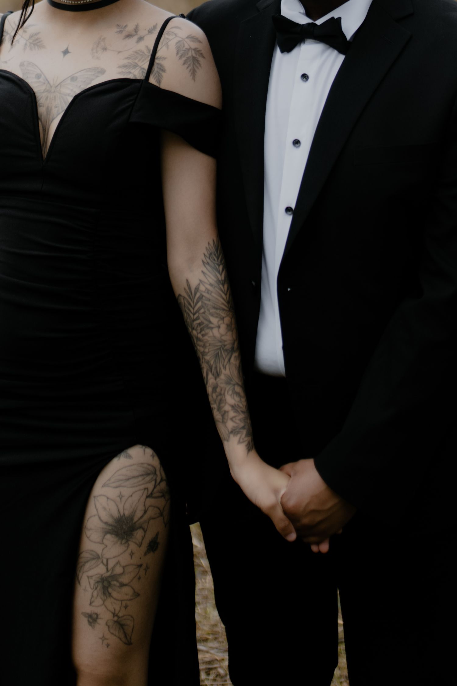 Detail shot of tattooed arms against formal black and white attire.