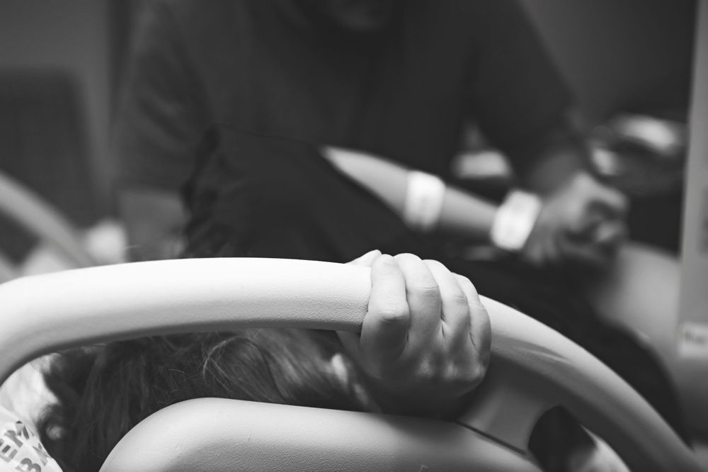 Hand grips the hospital bed during labor.
