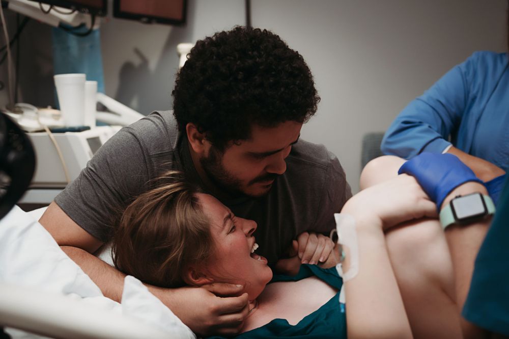 Woman pushing baby out during birth.