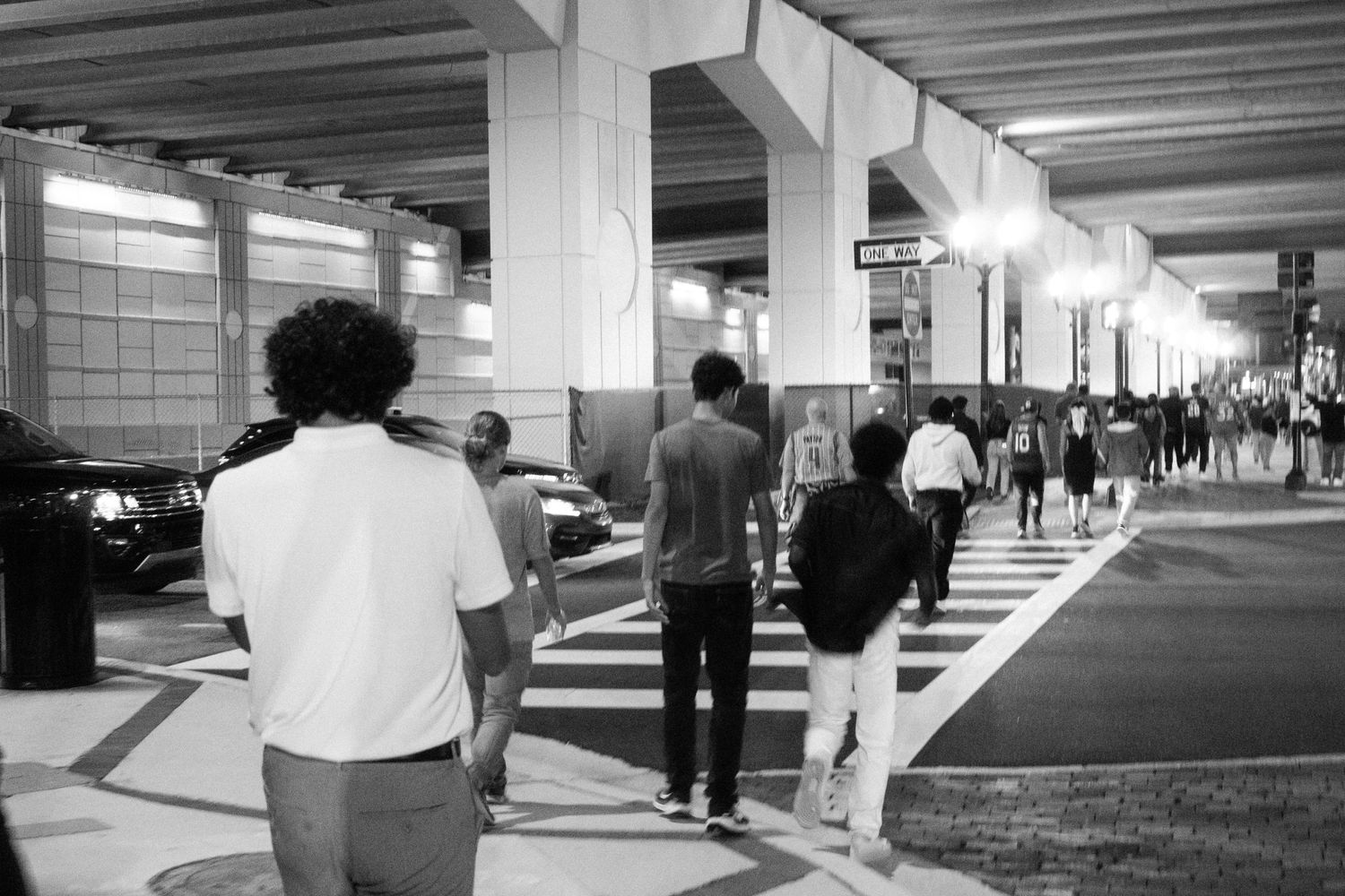 Long concrete hallway with people walking through an industrial or institutional building.