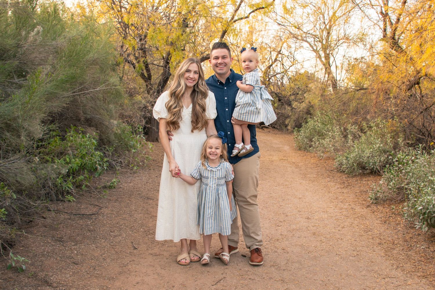 young family poses together in an autumn path in Mesa, Utah.
