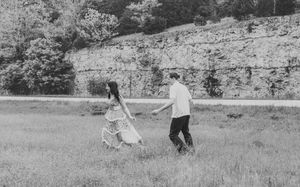 couple chasing each other black and white photo cliffs field
