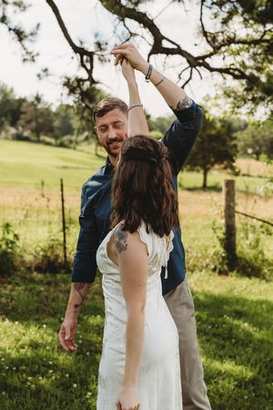 couple husband and wife white dress blue shirt khakis holding hands anniversary dancing