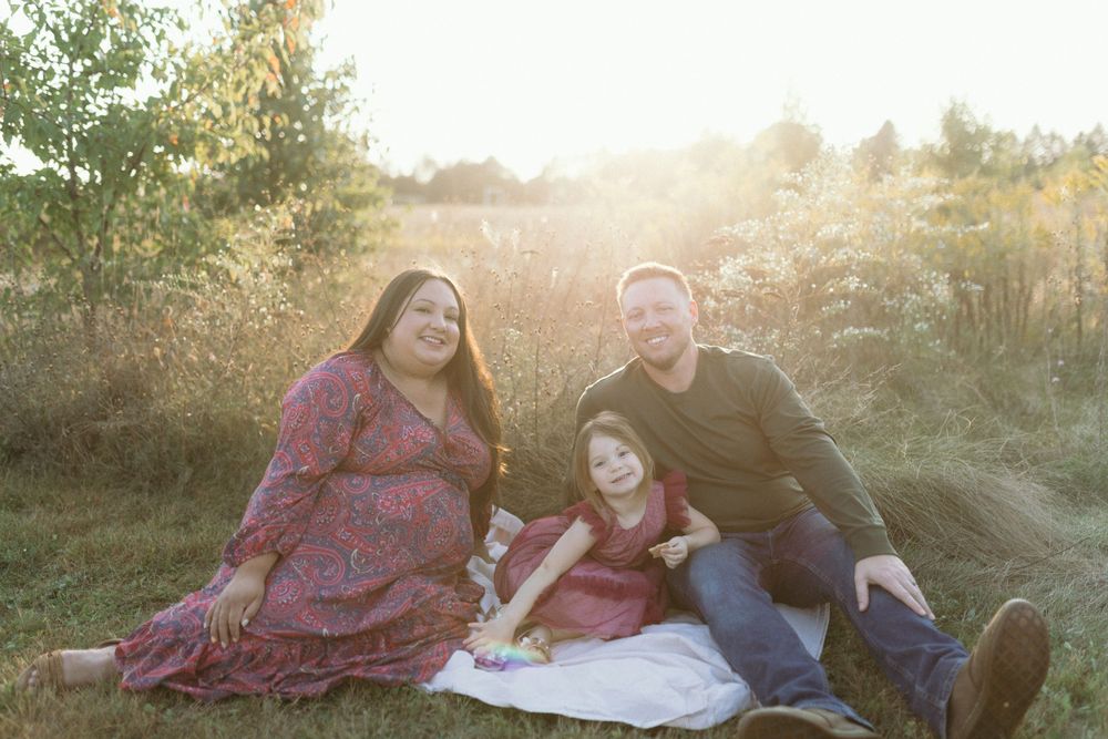 A relaxed family photo session on a blanket during golden hour.