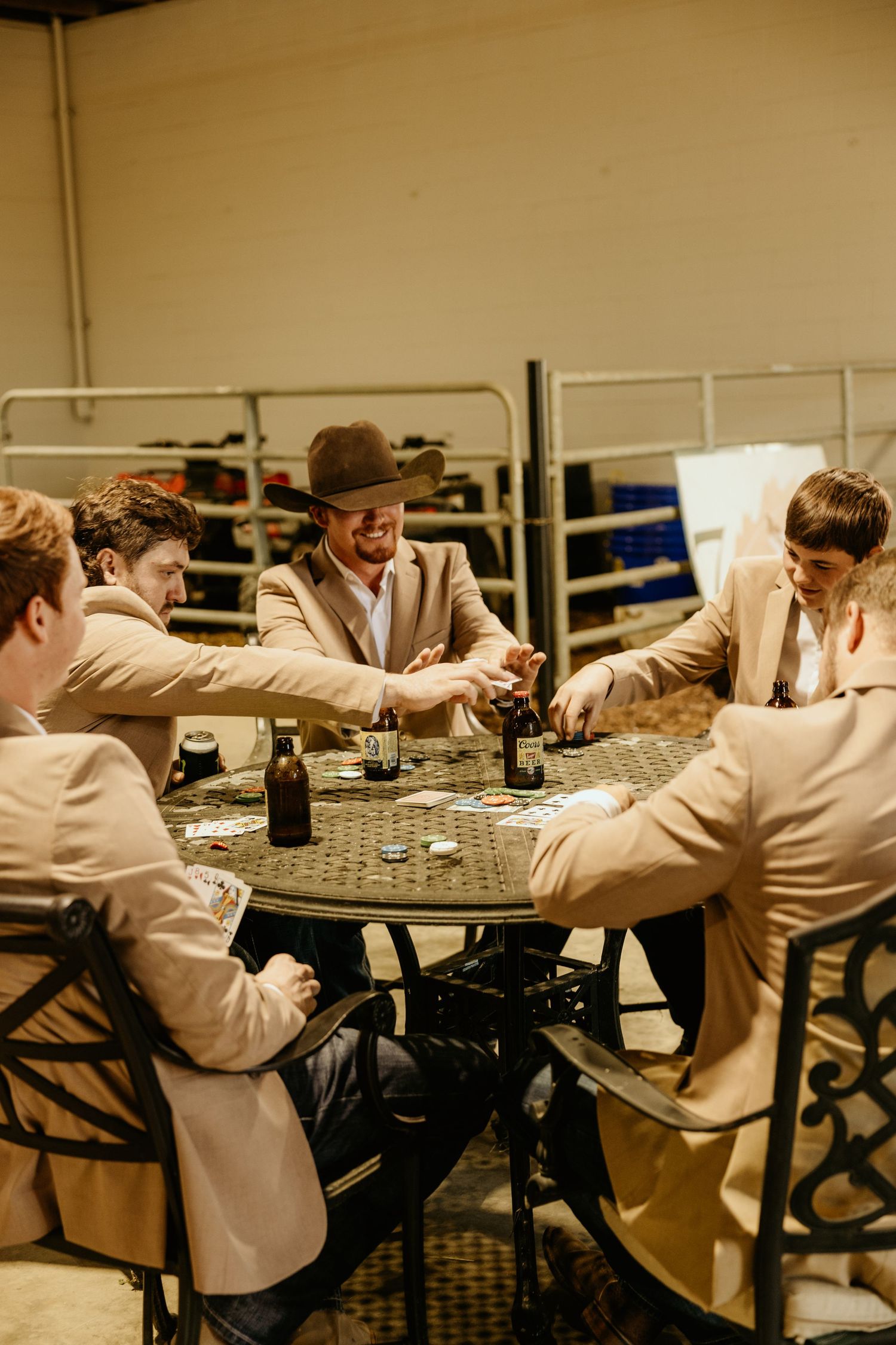 Group playing cards at outdoor table wearing matching tan blazers.