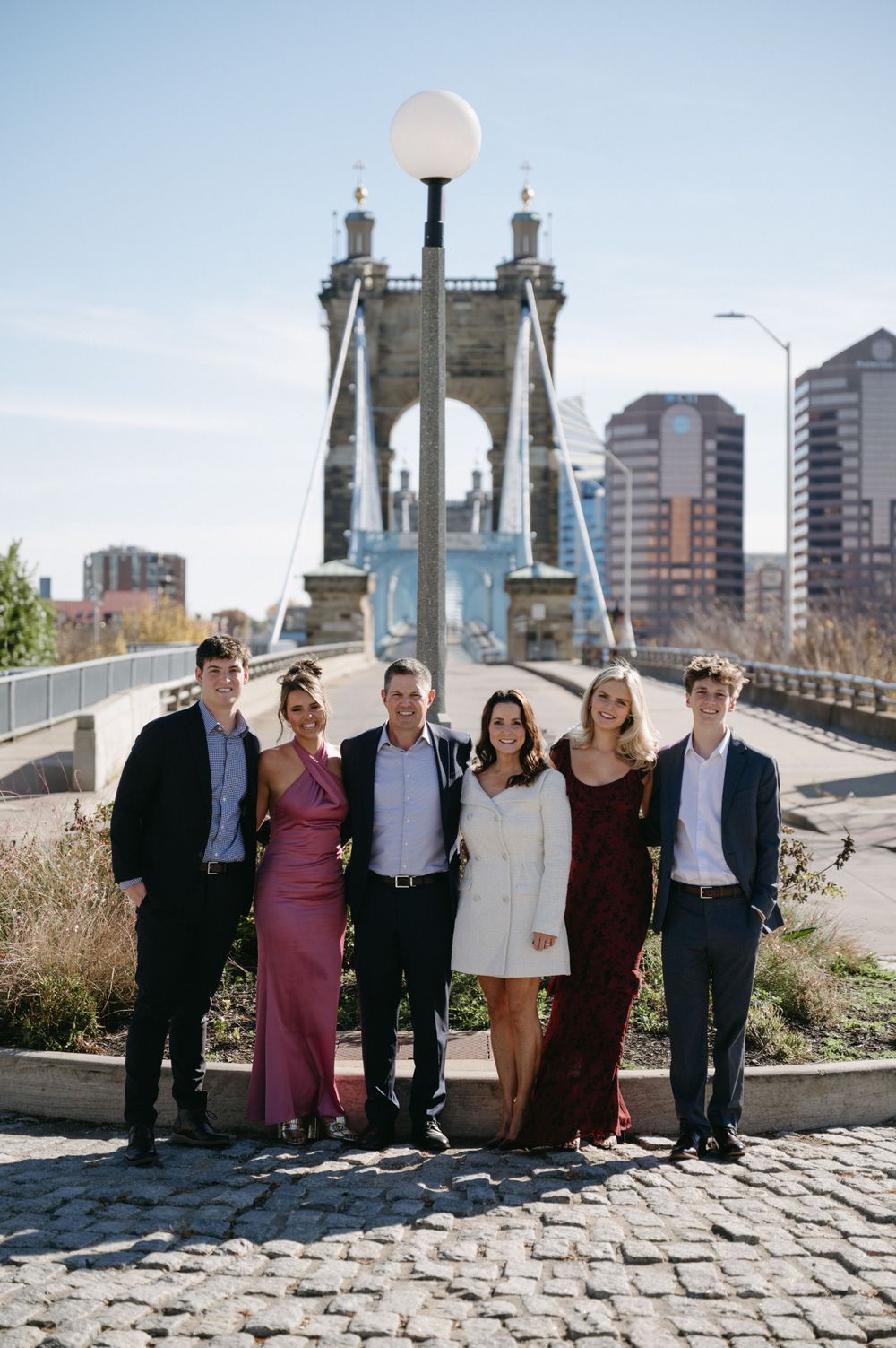 Group portrait in front of historic bridge tower with city skyline in background.