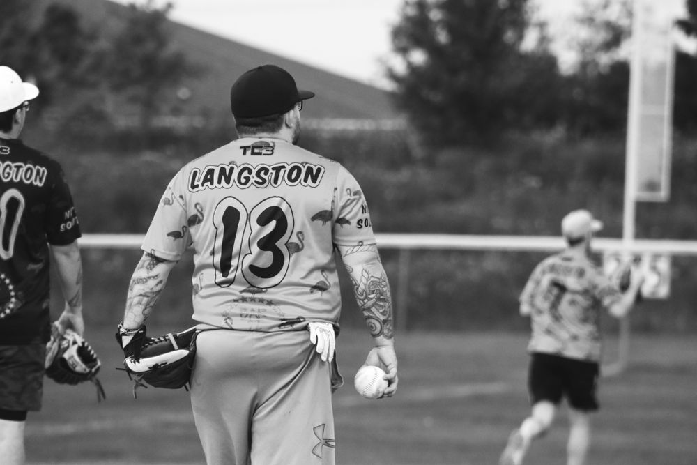 Baseball player wearing jersey number 13 with Langston on back during game.
