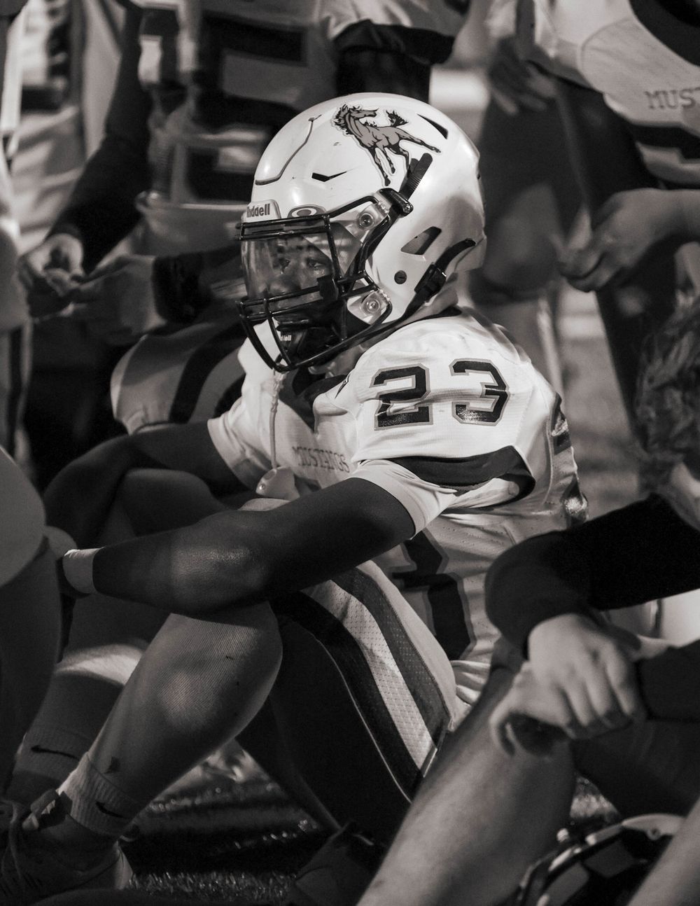 Football player number 23 in action during black and white game photo.