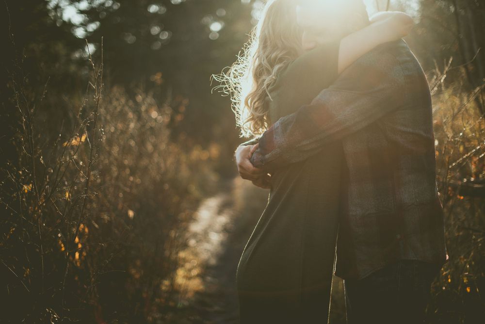 Ethereal silhouette stands in golden sunlit field during sunset with backlit glow creating atmospheric mood Edmonton Engagement Photographer