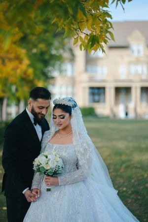 Wedding portrait in autumn setting featuring full lace ball gown and classic tuxedo.
