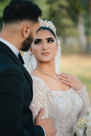 An intimate wedding photo highlighting a beaded gown, crystal headpiece and elegant jewelry.