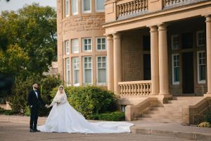 An elegant wedding photo featuring a flowing white gown against classical architecture.