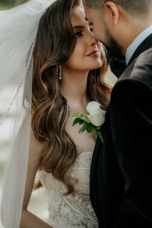 Intimate wedding portrait showing the details of a lace dress, flowing veil and romantic styling.