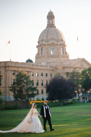 Elegant wedding photo in front of a grand legislative building with domed architecture.