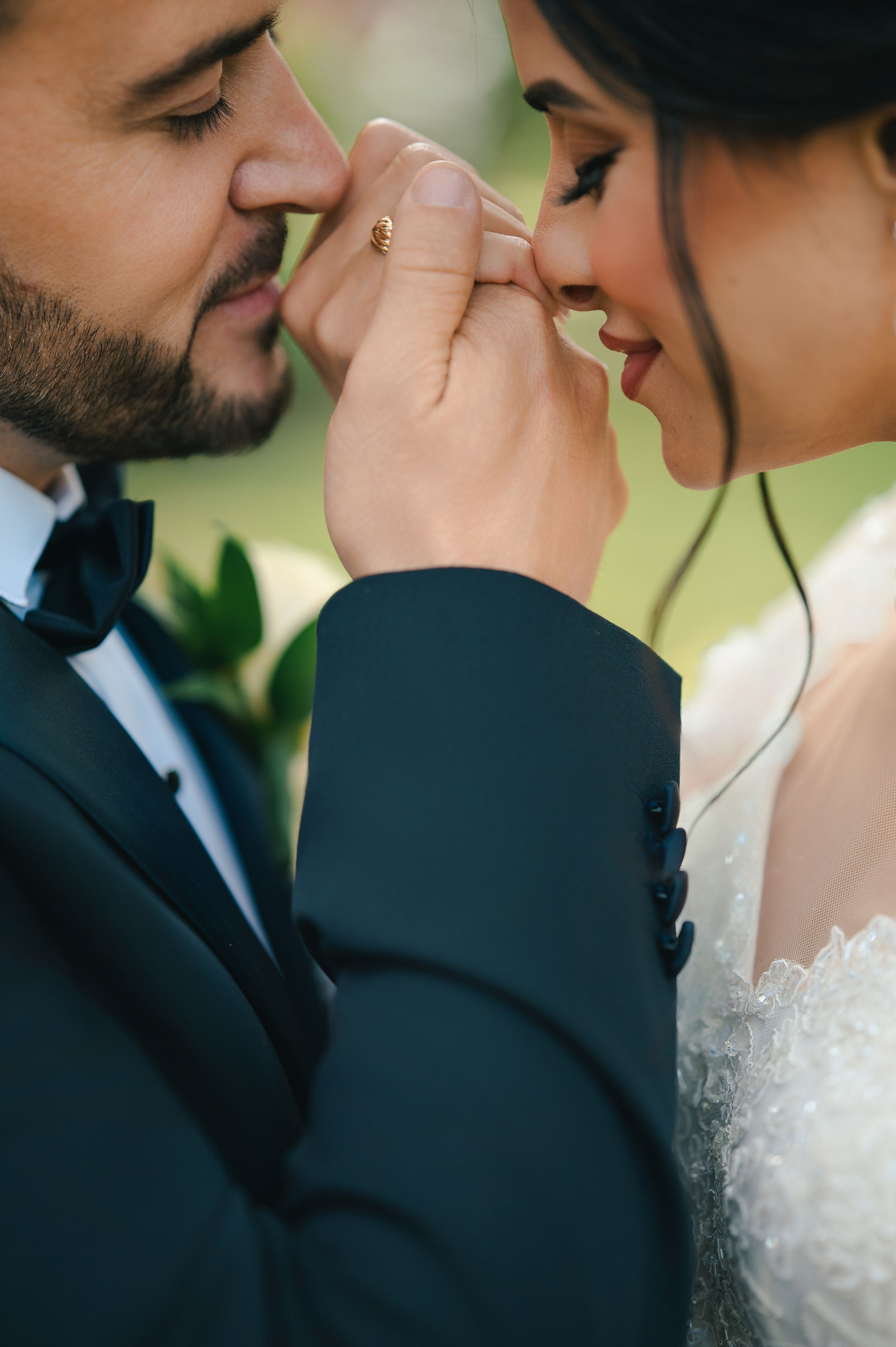 Intimate wedding moment captured with soft focus and natural outdoor lighting.