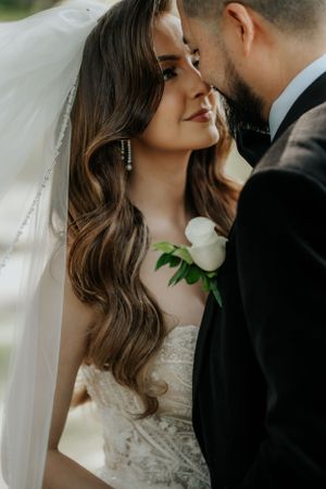 Intimate wedding portrait showing the details of a lace dress, flowing veil and romantic styling.