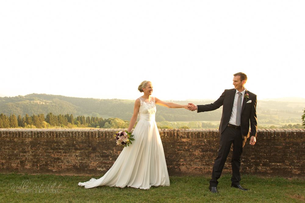 Couple dances together at sunset against a scenic countryside backdrop.