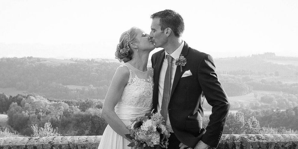 A romantic black and white wedding moment overlooking a scenic countryside landscape.