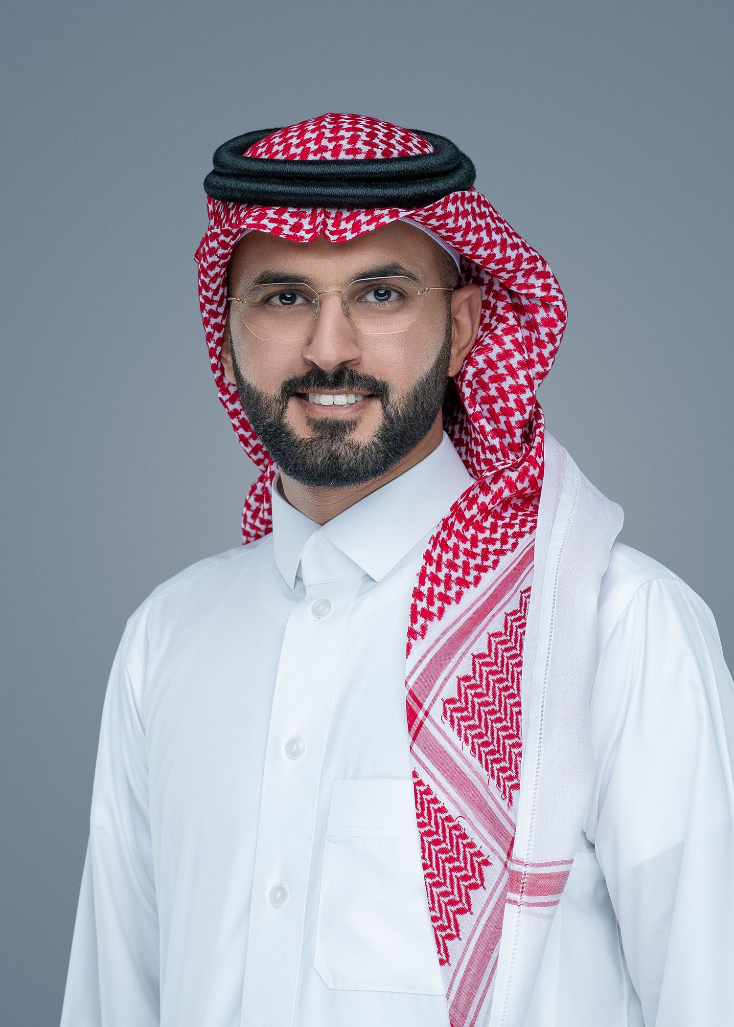 A person wearing traditional Middle Eastern dress including a white thobe and red and white checkered keffiyeh headdress.