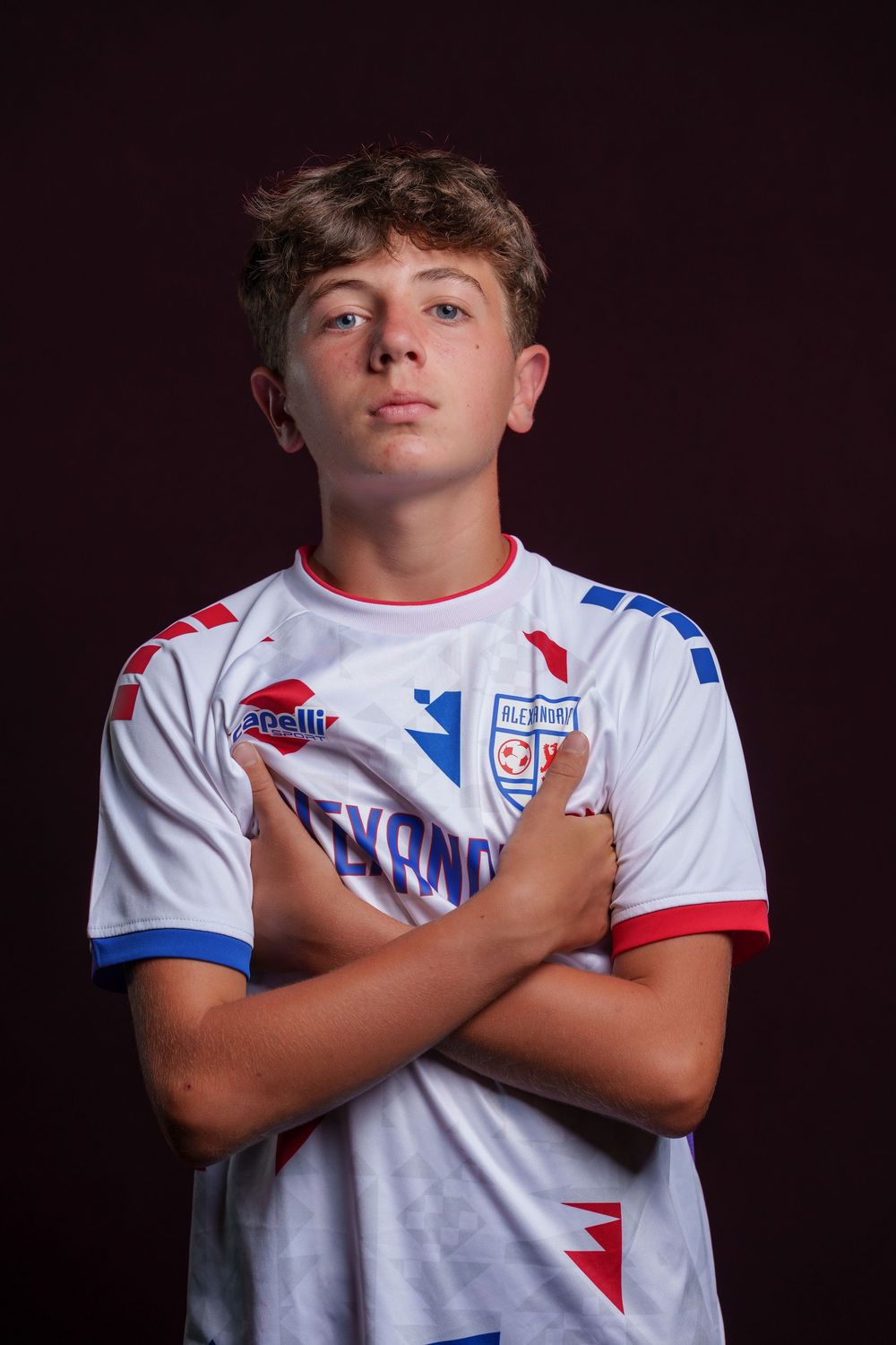 Athletes in white jerseys with red and blue accents cross their arms in a series of promotional sports portraits.