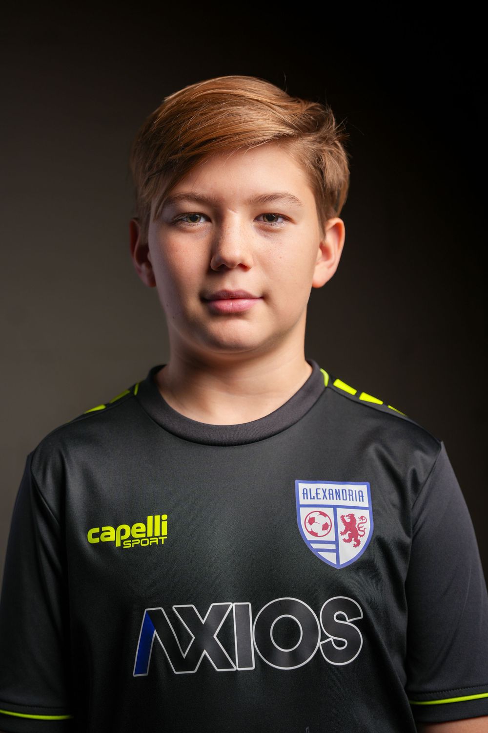 Youth athlete wearing black Capelli sport jersey with Axios sponsorship and team crest.